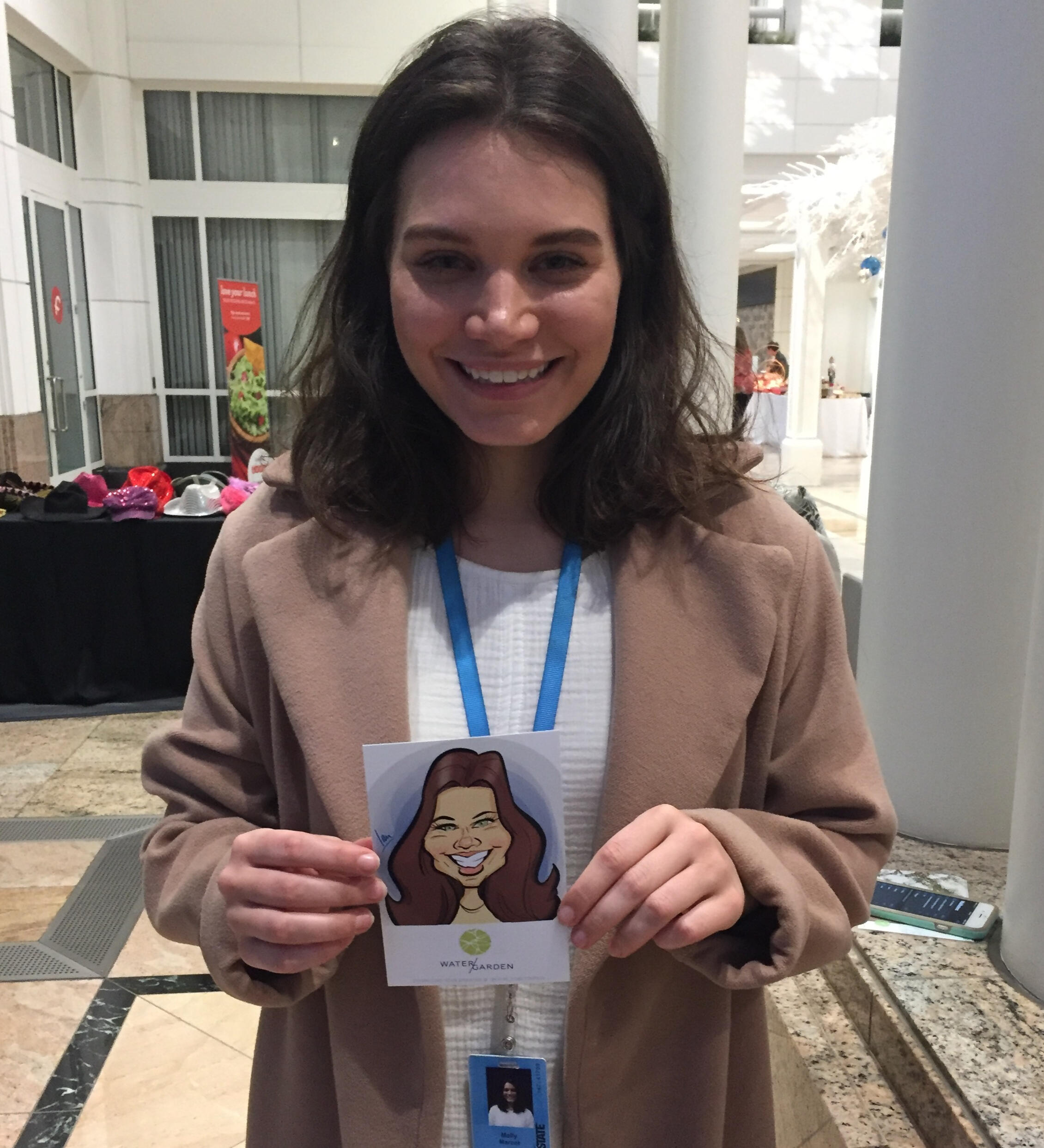 A satisfied guest holding her printed digital caricature art.